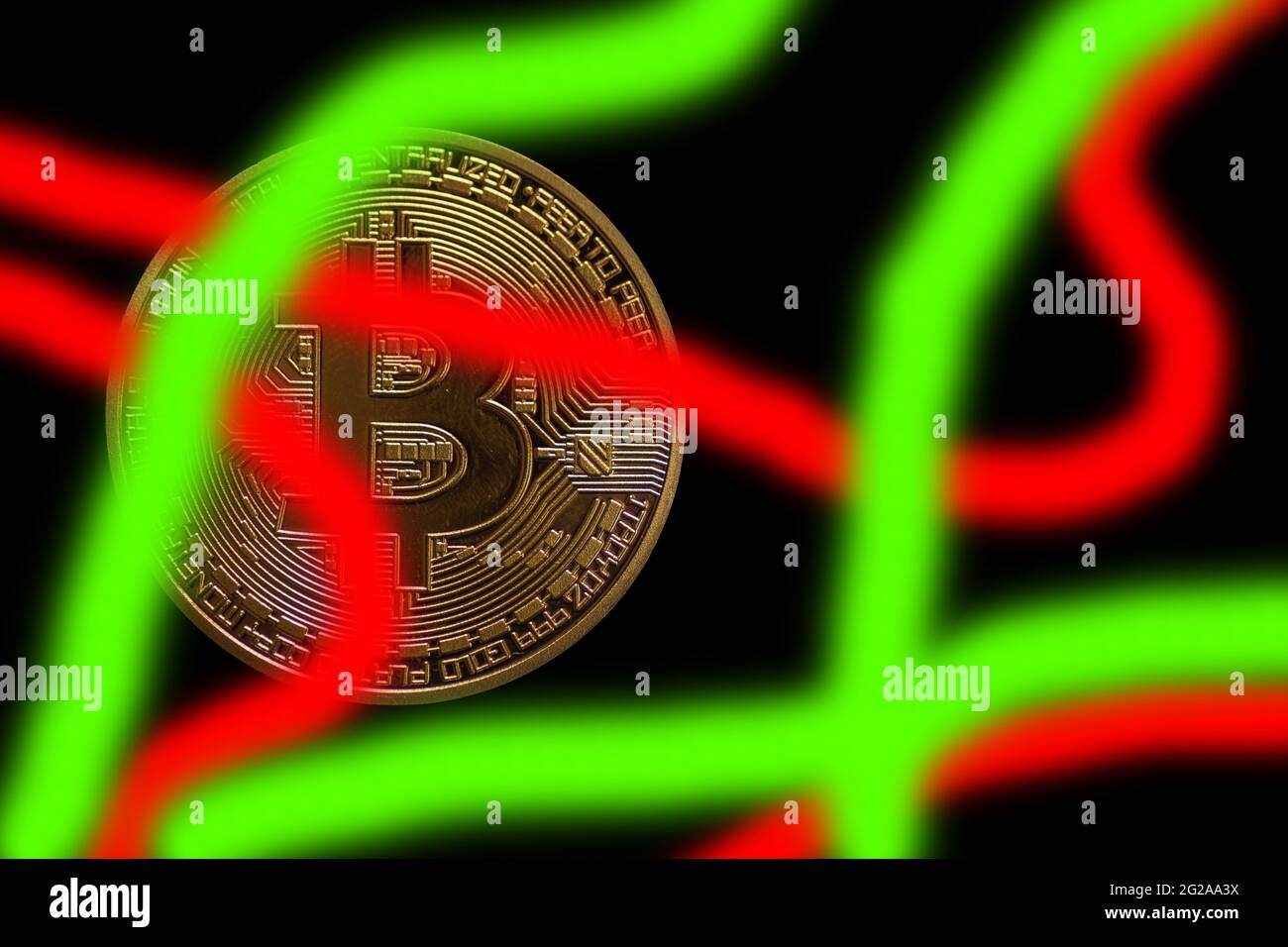 une monnaie unique de crypto-monnaie en bitcoin doré sur fond noir foncé avec des bandes rouges vertes Banque D'Images