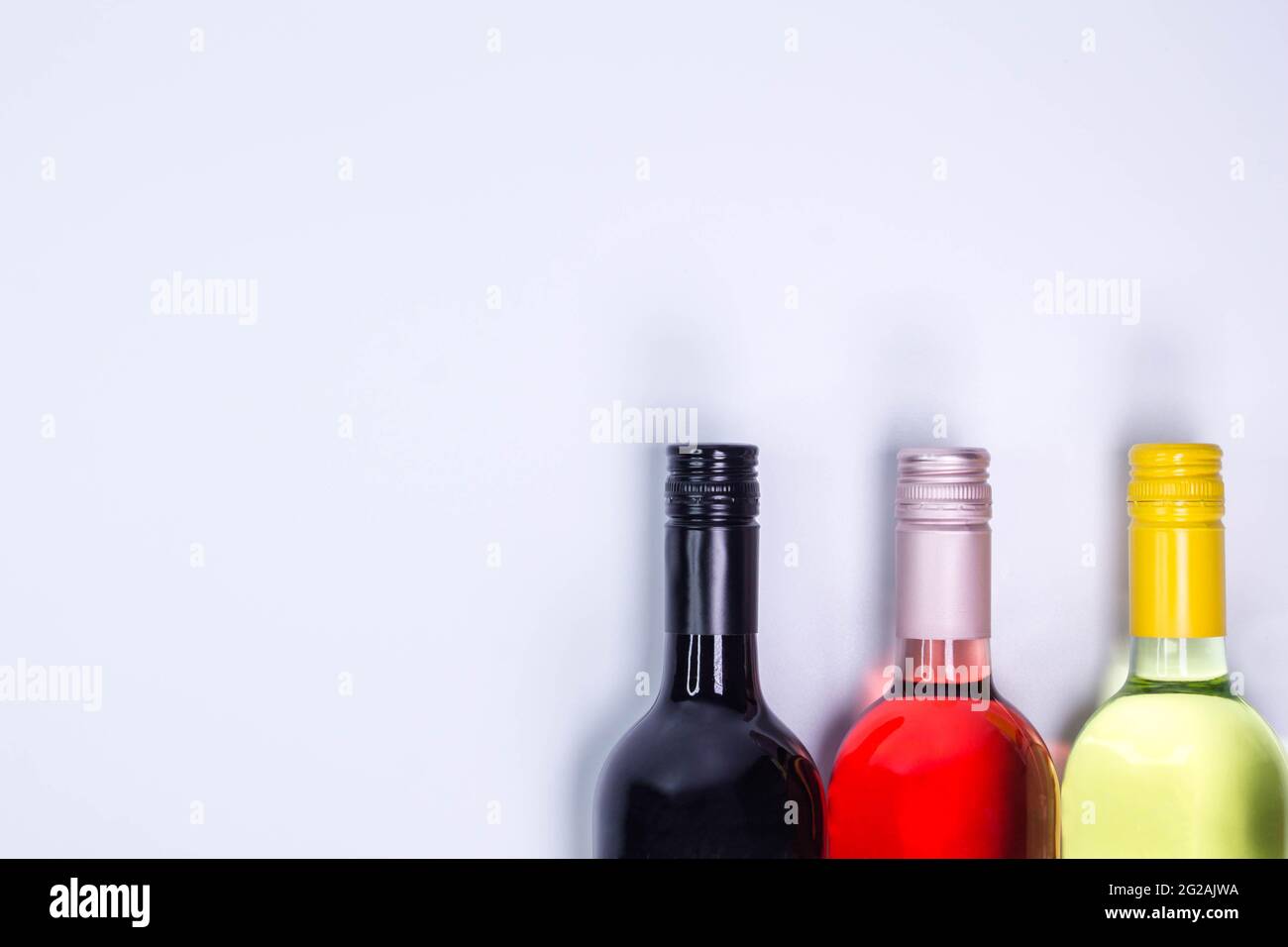 Bouteilles de vin rouge, rose et blanc sur table blanche. Vue de dessus avec espace de copie Banque D'Images