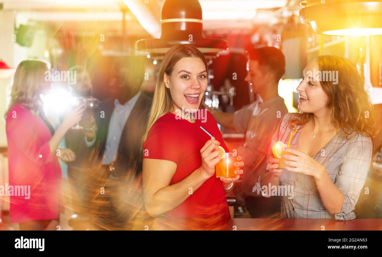 Les jeunes femmes boivent des cocktails et parlent à la fête Photo ...