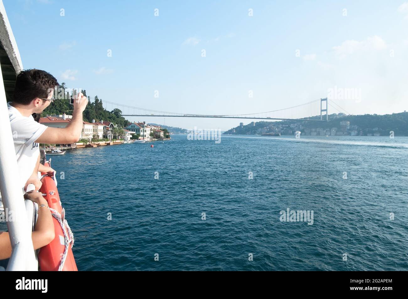 Istanbul, Turquie - 17 juillet 2010 : panoramique d'un touriste qui prend une photo du détroit de Bosporus et du pont de Bogazici depuis un ferry Banque D'Images