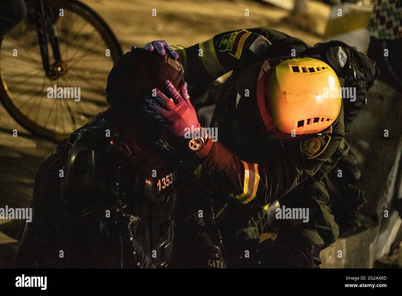 Un officier de police anti-émeute colombien (ESMAD) est assité après que Debree ait défait son visage lors d'affrontements avec des manifestants alors que les équipes colombiennes et Argentine ont joué un match de qualification pour la coupe du monde FIFA Quatar 2022 au stade Metropolitano Roberto Melendez, Les manifestations entourant le stade se sont intensifiés et ont provoqué des affrontements avec la police anti-émeutes de Colombie (ESMAD) contre les troubles et les brutalités policières, à Barranquilla, en Colombie, le 8 juin 2021. Banque D'Images
