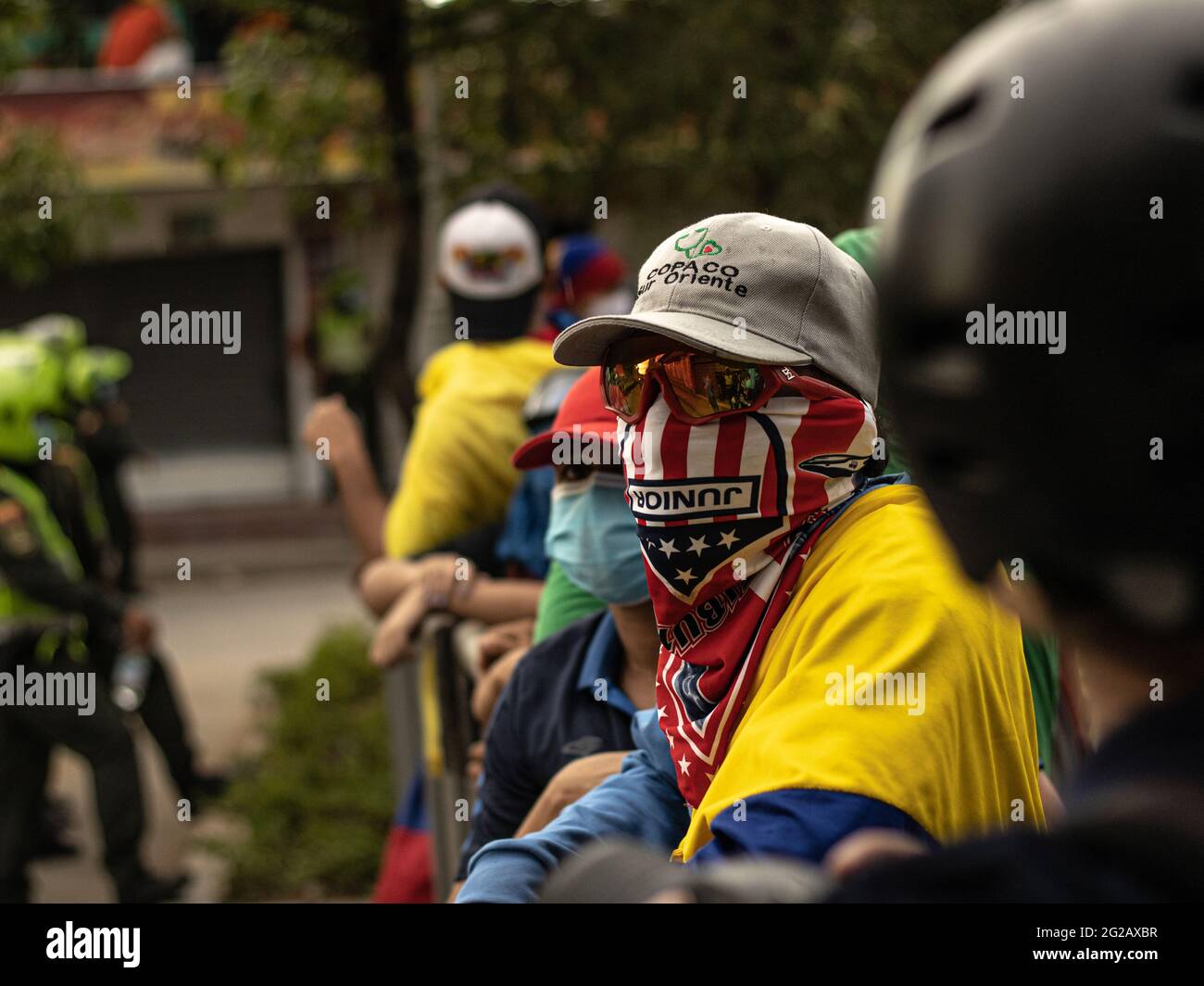 Un démonstrateur couvre son visage avec un maillot de football de l'équipe nationale colombienne et un foulard de l'équipe locale Junior tandis que les équipes colombiennes et Argentine ont joué un match qualifiant pour la coupe du monde FIFA Quatar 2022 au stade Metropolitano Roberto Melendez, Les manifestations entourant le stade se sont intensifiés et se sont heurtés à des affrontements avec la police anti-émeutes de Colombie contre les troubles et les brutalités policières, à Barranquilla, en Colombie, le 8 juin 2021. Banque D'Images