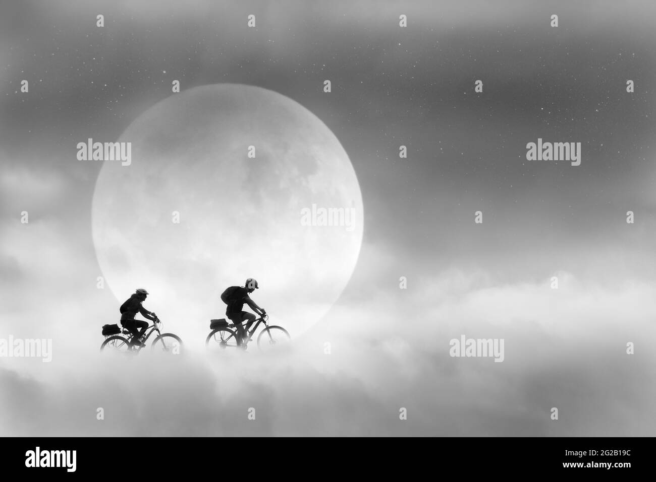 Image composite de deux jeunes en vélo dans les nuages passant la pleine lune avec des étoiles dans le ciel. Une image fantastique en noir et blanc. Banque D'Images