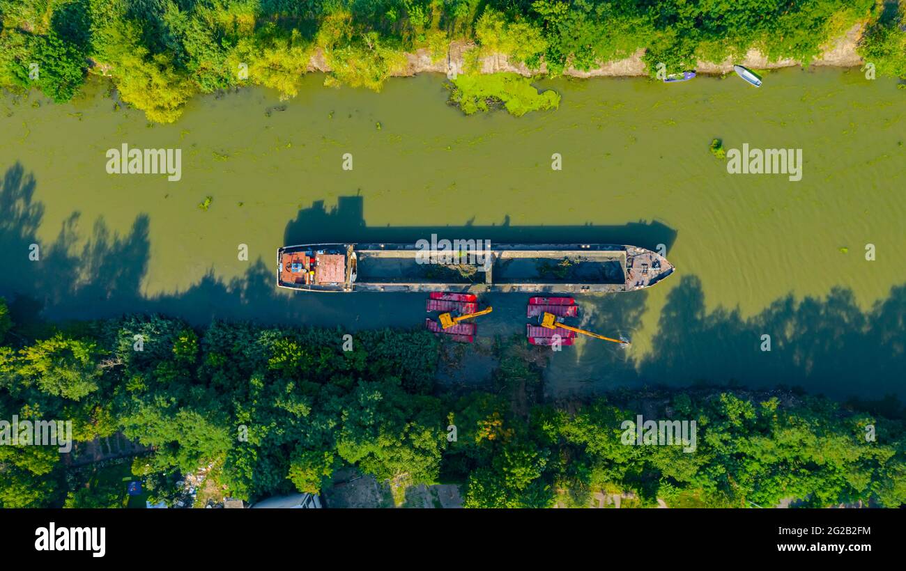 Au-dessus de la vue de dessus sur deux excavatrices drague comme ils dragage, travaillant sur la rivière, canal, l'approfondissement et l'enlèvement des sédiments, la boue du lit de fleuve dans une wa polluée Banque D'Images