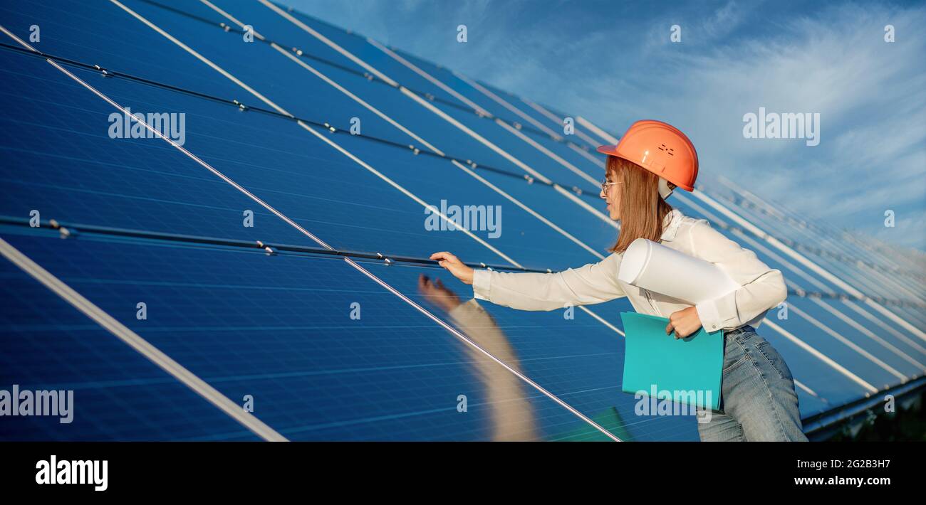 Femmes d'affaires travaillant à vérifier l'équipement à la centrale solaire avec la liste de contrôle des tablettes, femme travaillant à l'extérieur à la centrale solaire. Banque D'Images