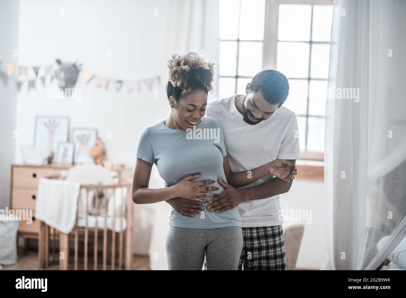 Un homme heureux touchant le ventre avec ses paumes Banque D'Images