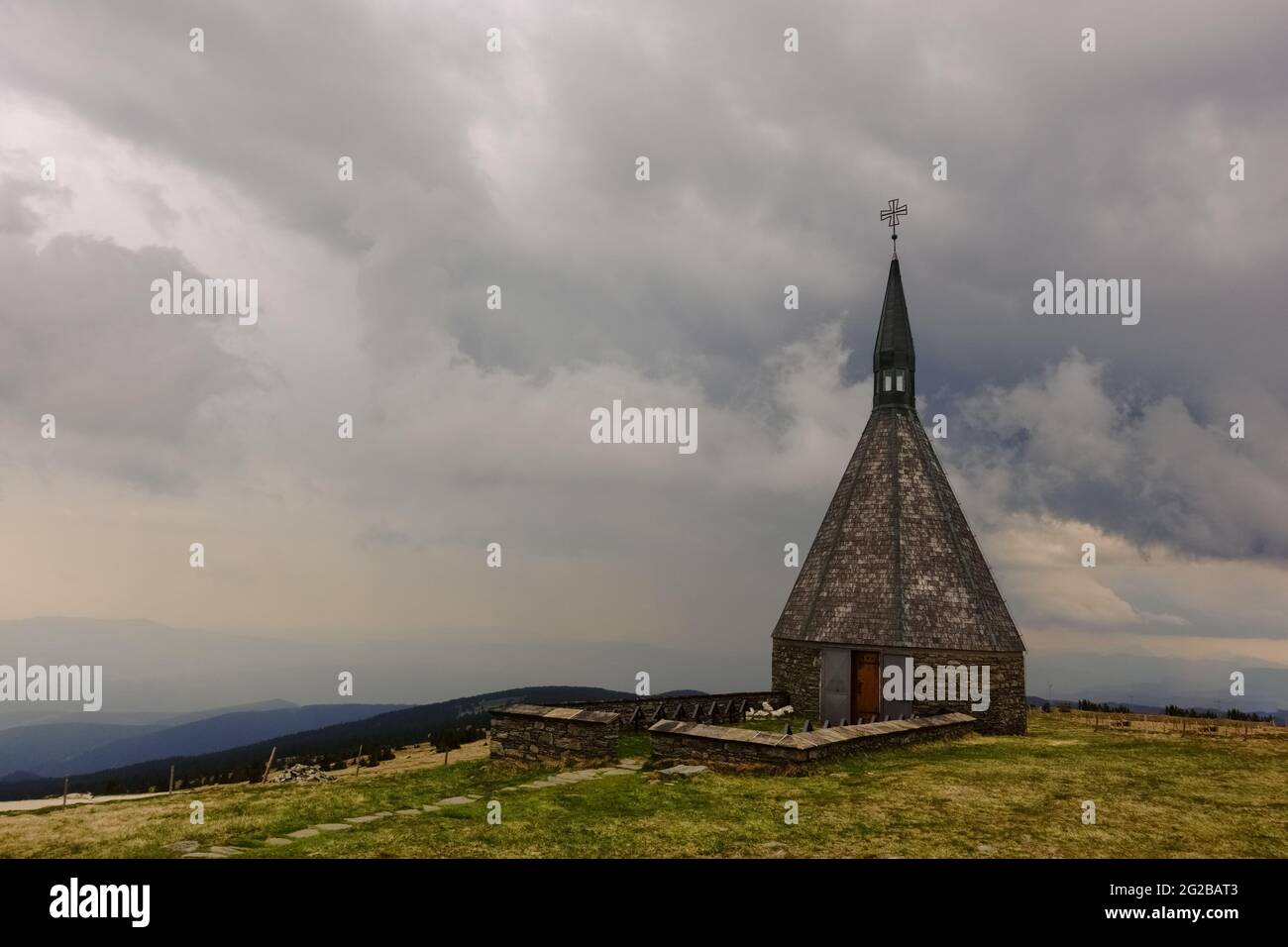 petite chapelle avec nuages de pluie sur le sommet d'une montagne pendant la randonnée Banque D'Images