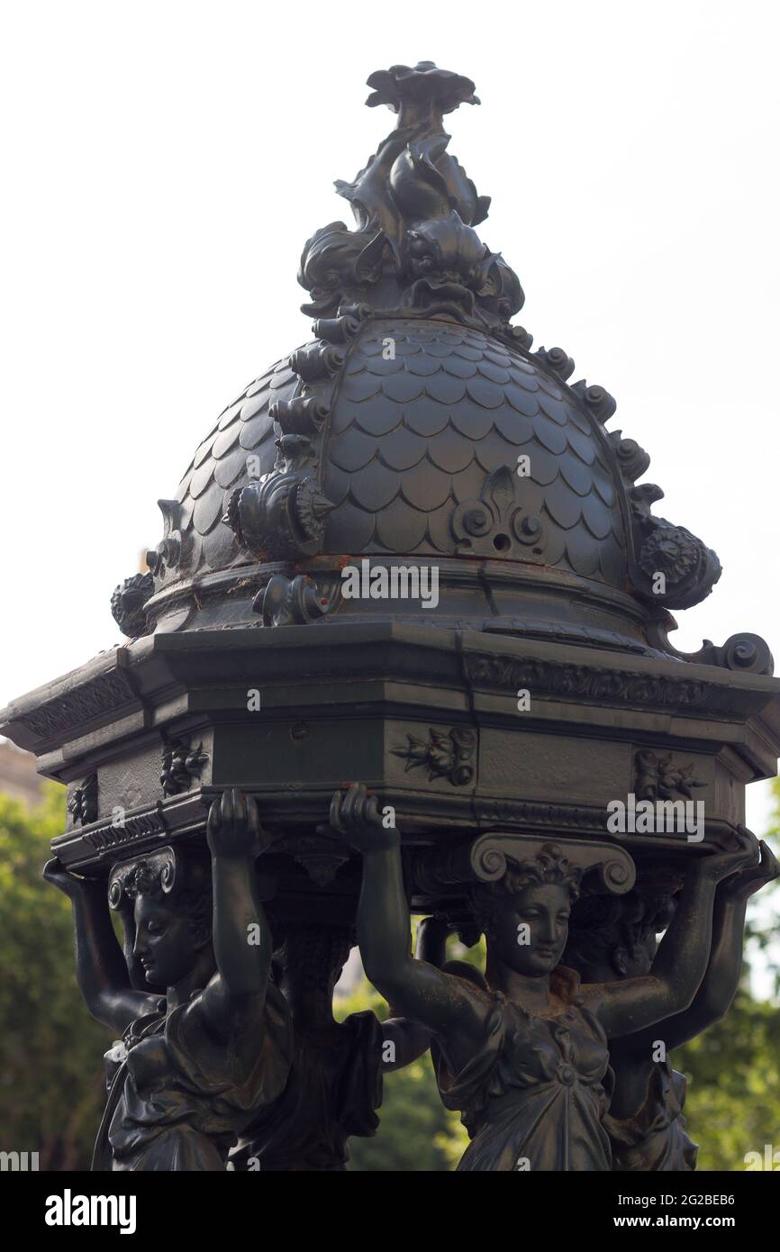 Couronne avec des figures d'une vieille fontaine en fer dans le centre-ville de Barcelone, Catalogne, Espagne. Banque D'Images