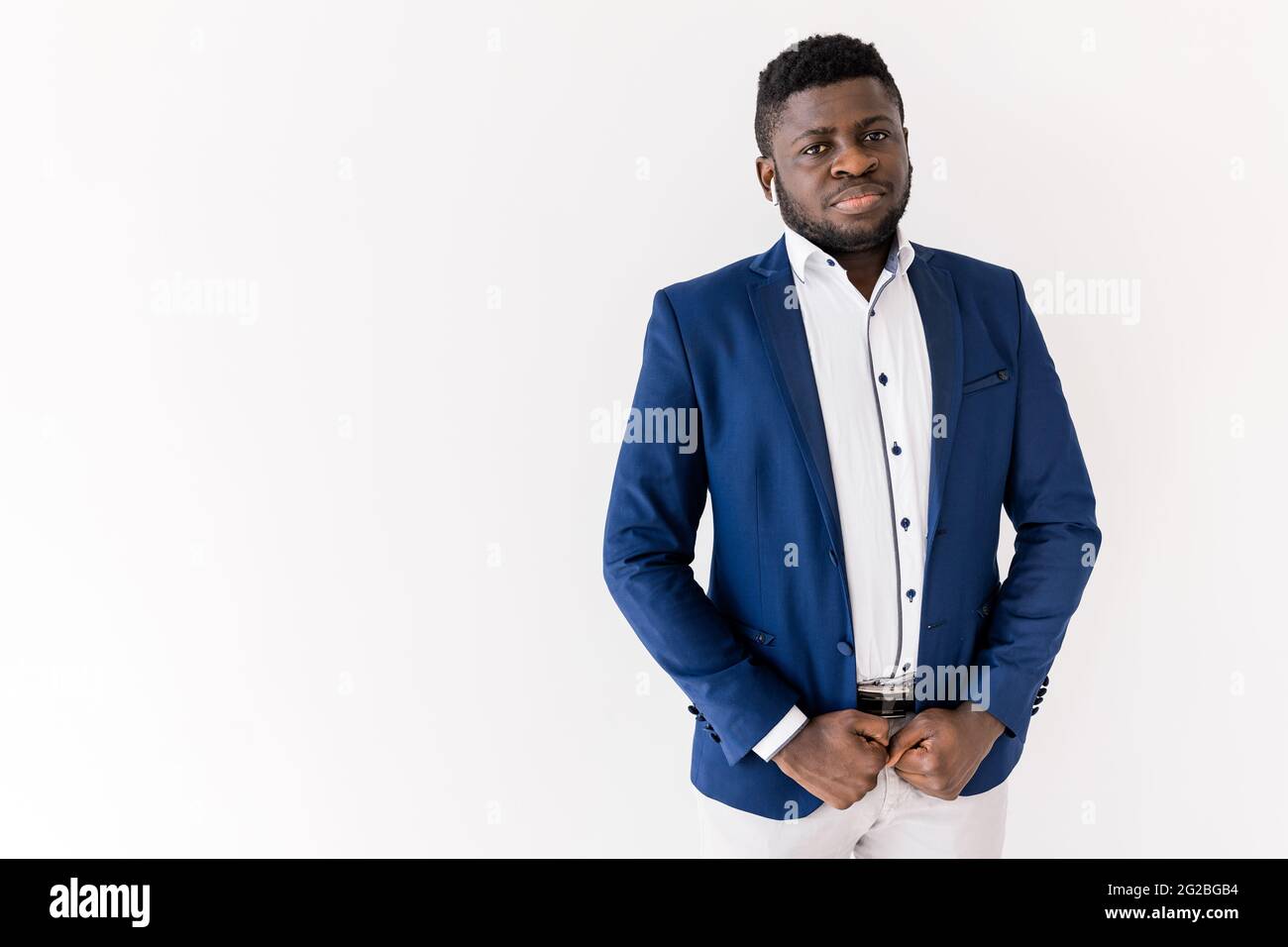Photo de la tête d'un jeune homme afro-américain sérieux portant une chemise et un costume blancs regardant la caméra debout sur fond blanc, studio de copie d'espace Banque D'Images