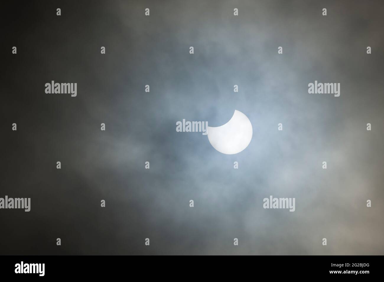 Une éclipse solaire partielle du Soleil vue à travers le nuage le 10 juin 2021 vue du nord du Somerset, en Angleterre. Banque D'Images