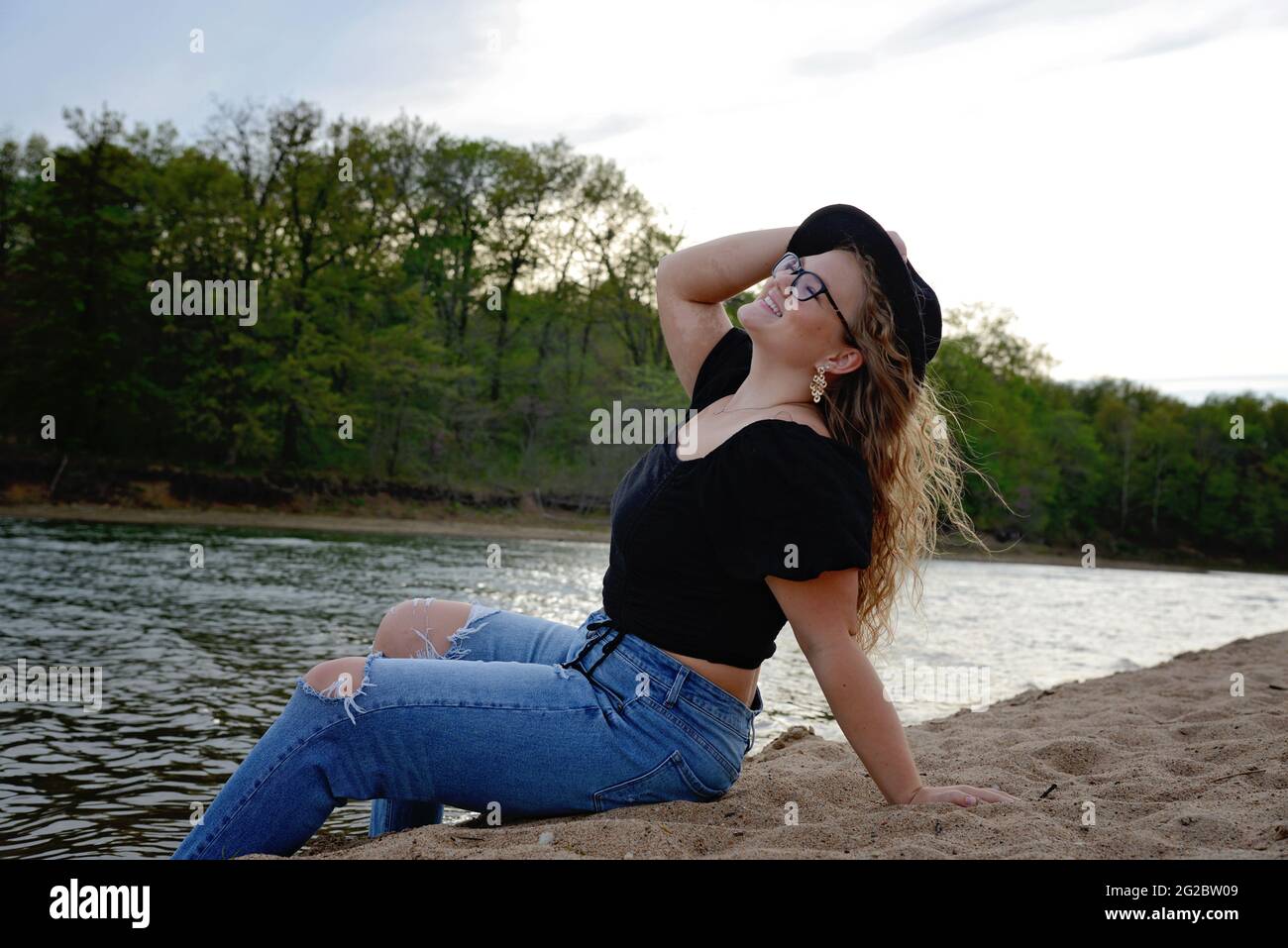 Belle fille de cheveux blond portant une chemise noire et un Jean Banque D'Images