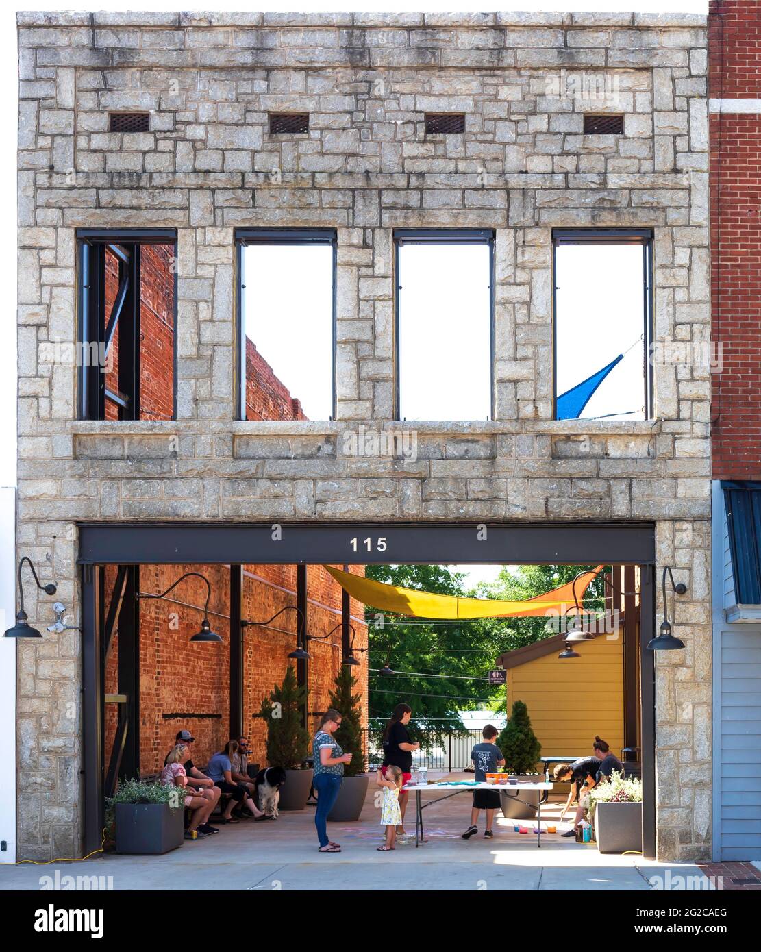 ELKIN, NC, USA-5 JUIN 2021: Un espace dans une ligne de bâtiments où il ne reste que la façade de l'ancien bâtiment. Les personnes qui se reposent avec des enfants. Verti Banque D'Images