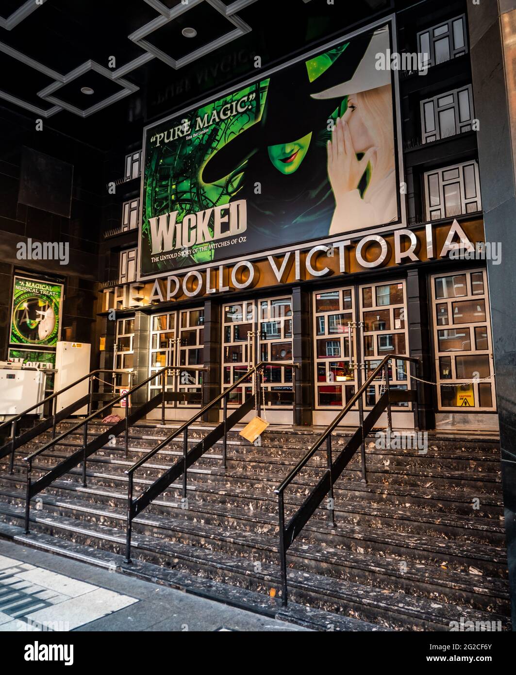 L'Apollo Theatre Victoria dans le West End de Londres avec des affiches annonçant la production actuelle de la comédie musicale, Wicked. Banque D'Images L'Apollo Theatre Victoria dans le West End de Londres avec des affiches annonçant la production actuelle de la comédie musicale, Wicked. Banque D'Images