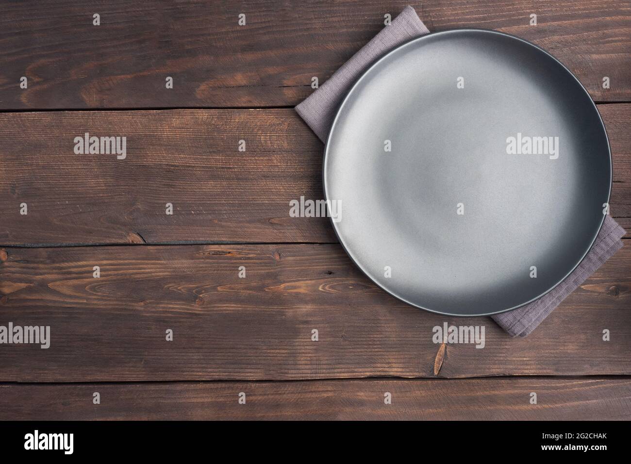 Assiette noire vide sur fond rustique en bois. Vue de dessus avec espace de copie Banque D'Images Assiette noire vide sur fond rustique en bois. Vue de dessus avec espace de copie Banque D'Images