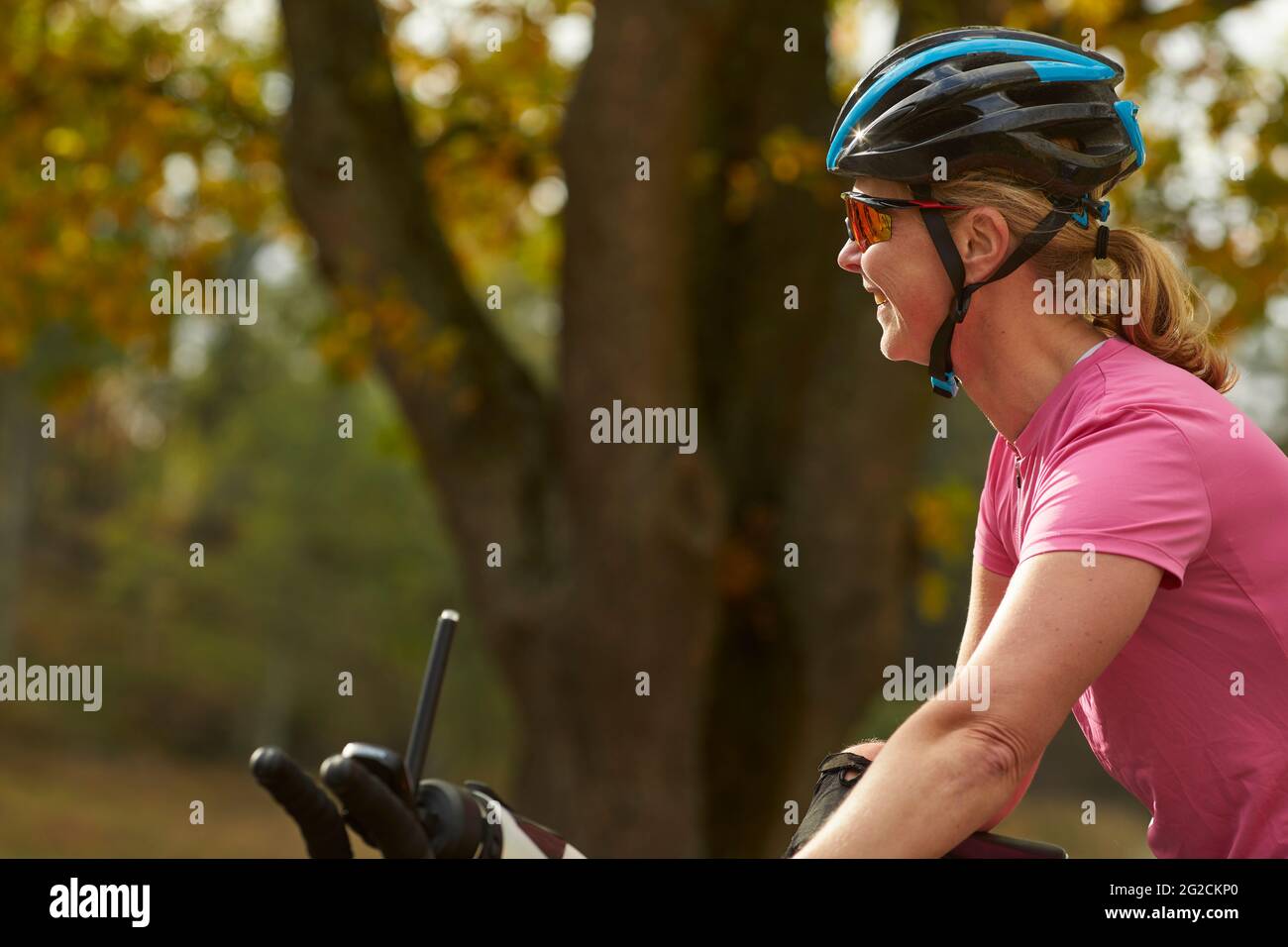 Femme cycliste souriante qui regarde loin Banque D'Images