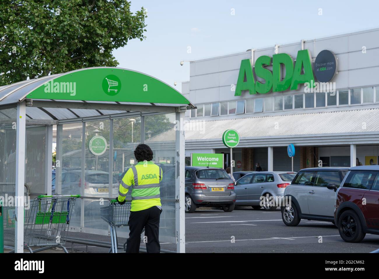 ASDA Shop assistance collecte le chariot vide du parc à chariots au magasin, Londres, Angleterre, Royaume-Uni Banque D'Images