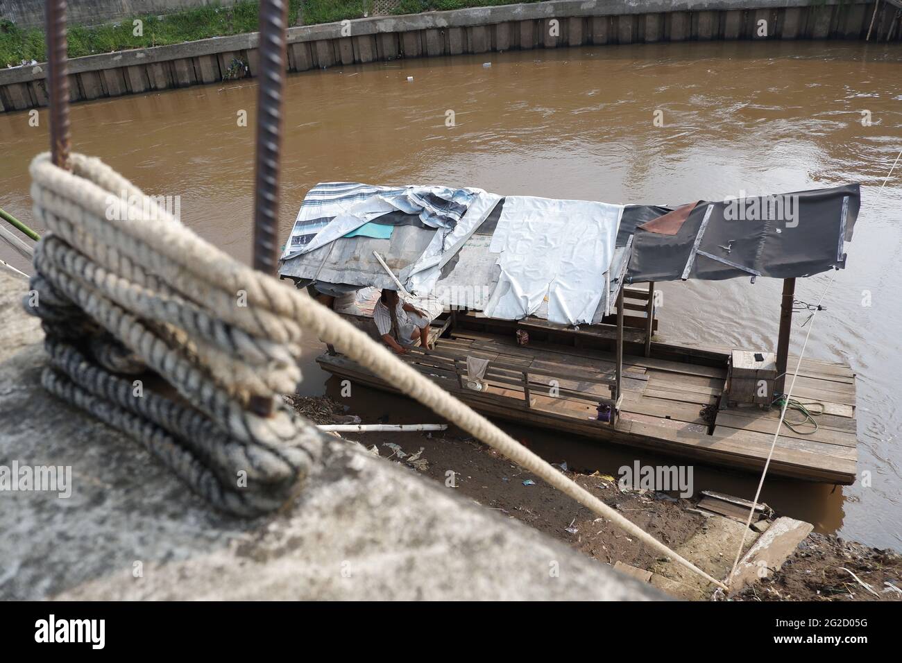 Entre Kampung Pulo et Kampung Melayu Kecil, dans la région de Jatinegara, dans l'est de Jakarta, en Indonésie, limitée par la partie du remblai qui retient la normalisation du débit de la rivière Ciliwung, il existe un service de traversée terrestre qui, jusqu'à présent, survit encore dans la capitale. Rohim (42) un homme de stock d'Indramayu, qui est également un chauffeur de Bajaj, prend tour à tour avec son ami Azis (45) qui retourne dans sa ville natale, en courant un service de traversée de bateau traînante pour survivre. (Photo de Kuncoro Widyo Rumpoko/Pacific Press) Banque D'Images
