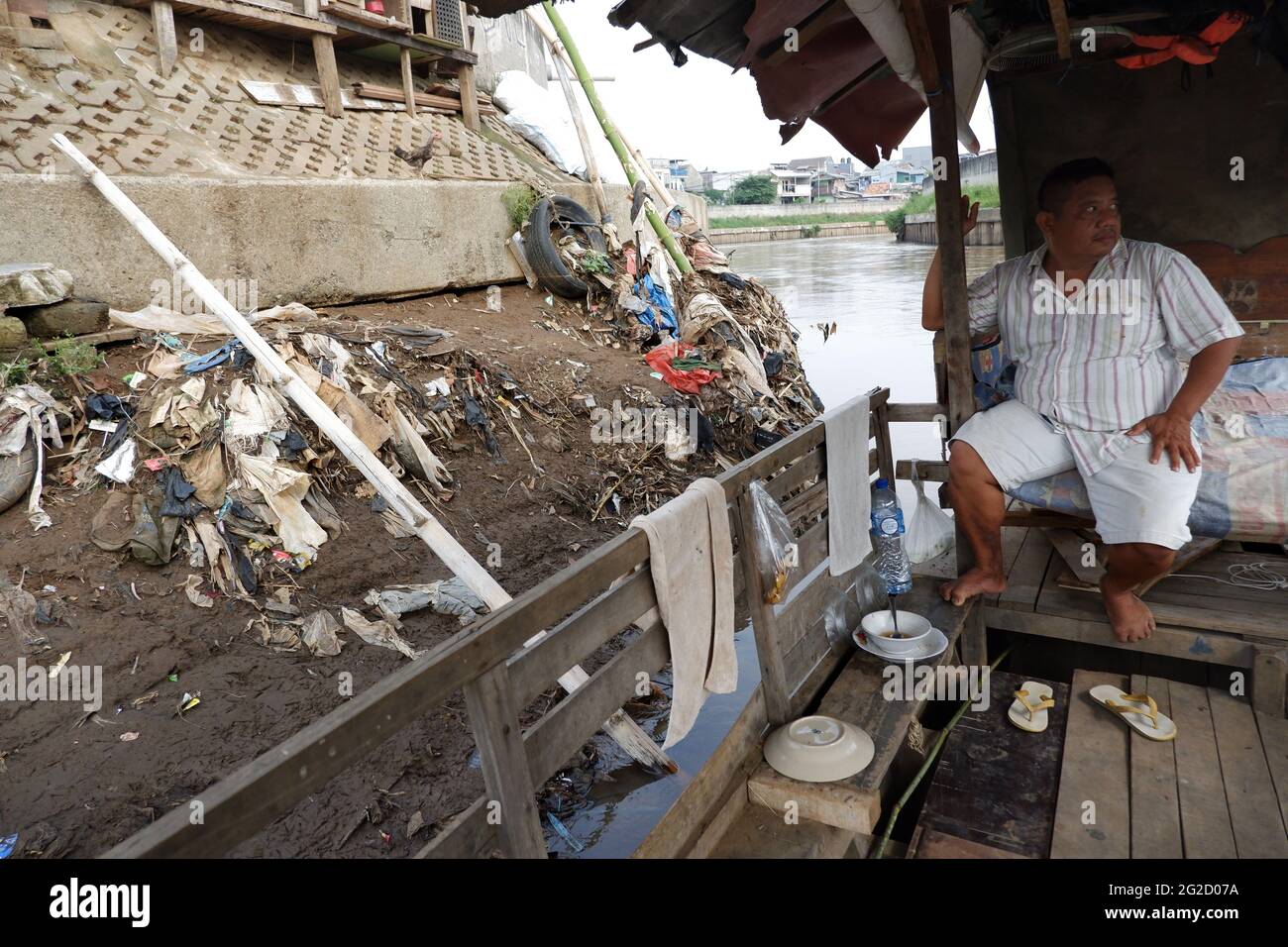 Entre Kampung Pulo et Kampung Melayu Kecil, dans la région de Jatinegara, dans l'est de Jakarta, en Indonésie, limitée par la partie du remblai qui retient la normalisation du débit de la rivière Ciliwung, il existe un service de traversée terrestre qui, jusqu'à présent, survit encore dans la capitale. Rohim (42) un homme de stock d'Indramayu, qui est également un chauffeur de Bajaj, prend tour à tour avec son ami Azis (45) qui retourne dans sa ville natale, en courant un service de traversée de bateau traînante pour survivre. (Photo de Kuncoro Widyo Rumpoko/Pacific Press) Banque D'Images
