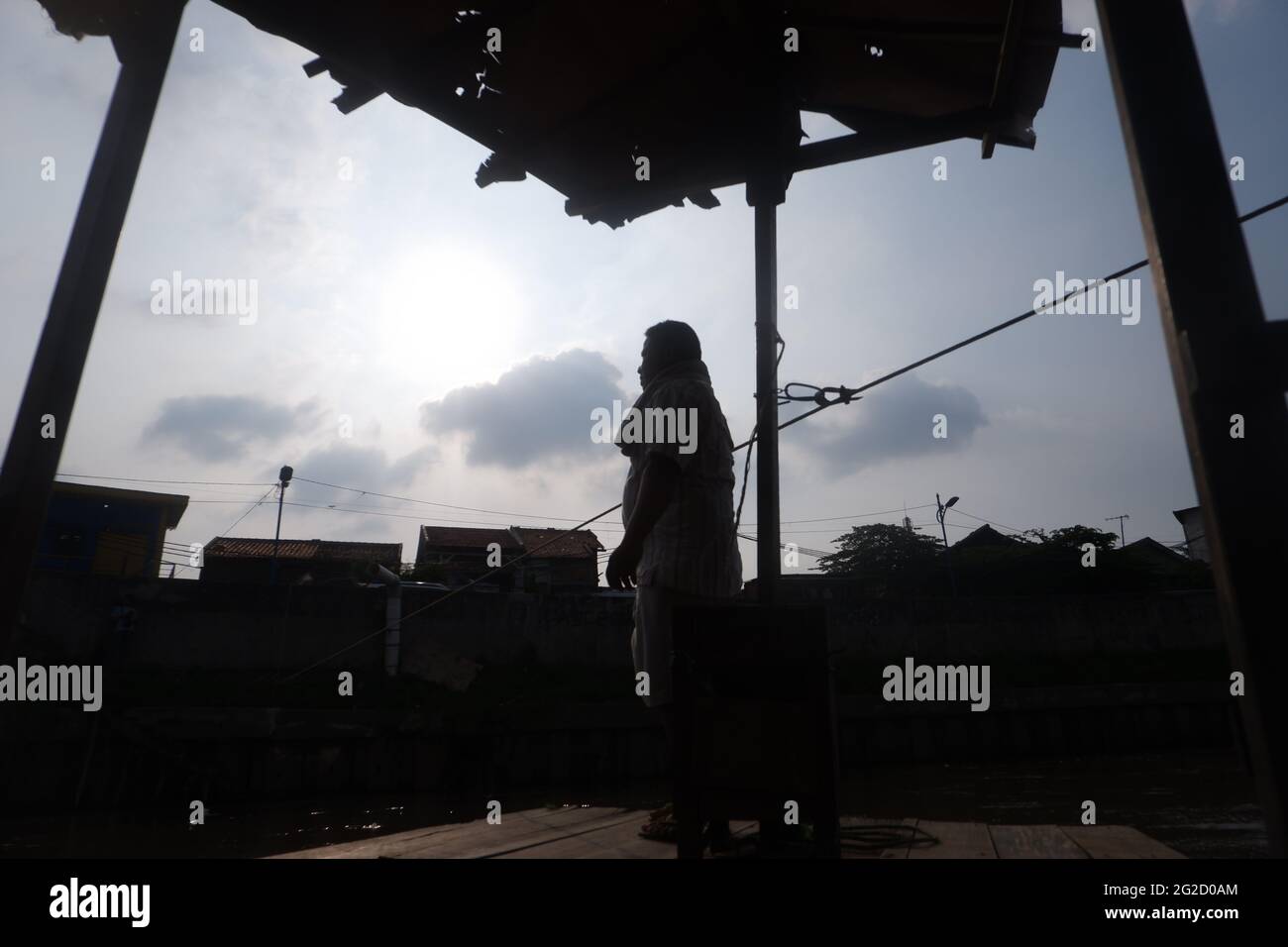 Entre Kampung Pulo et Kampung Melayu Kecil, dans la région de Jatinegara, dans l'est de Jakarta, en Indonésie, limitée par la partie du remblai qui retient la normalisation du débit de la rivière Ciliwung, il existe un service de traversée terrestre qui, jusqu'à présent, survit encore dans la capitale. Rohim (42) un homme de stock d'Indramayu, qui est également un chauffeur de Bajaj, prend tour à tour avec son ami Azis (45) qui retourne dans sa ville natale, en courant un service de traversée de bateau traînante pour survivre. (Photo de Kuncoro Widyo Rumpoko/Pacific Press) Banque D'Images