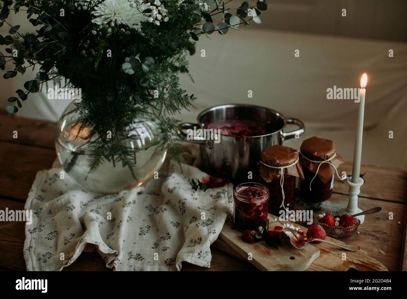 Pots avec confiture maison et fleurs fraîches dans un vase Banque D'Images