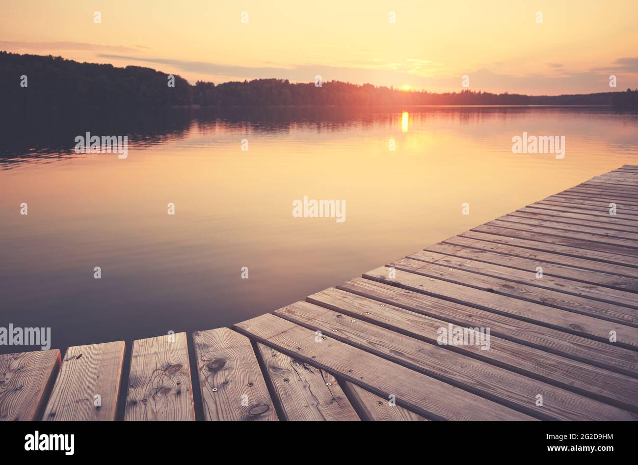 Jetée en bois au lac Lipie au coucher du soleil, mise au point sélective, coloration appliquée, Strzelce Krajenskie, Pologne. Banque D'Images Jetée en bois au lac Lipie au coucher du soleil, mise au point sélective, coloration appliquée, Strzelce Krajenskie, Pologne. Banque D'Images