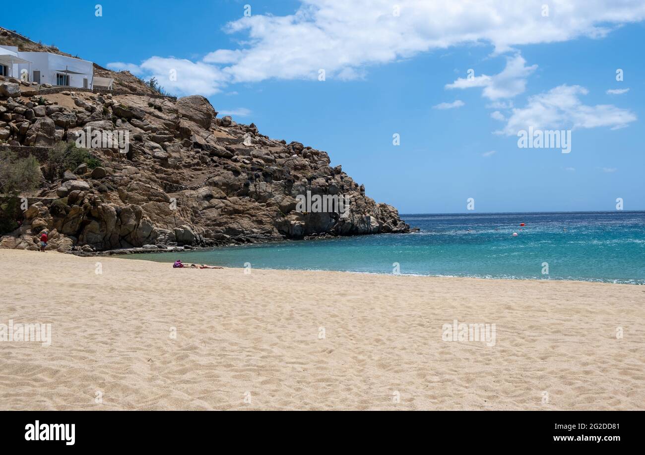 Île de Mykonos, Cyclades. Grèce. Plage de sable de Super Paradise, carte de vacances d'été et modèle de publicité. Bâtiment blanc sur la colline rocheuse, nuage Banque D'Images