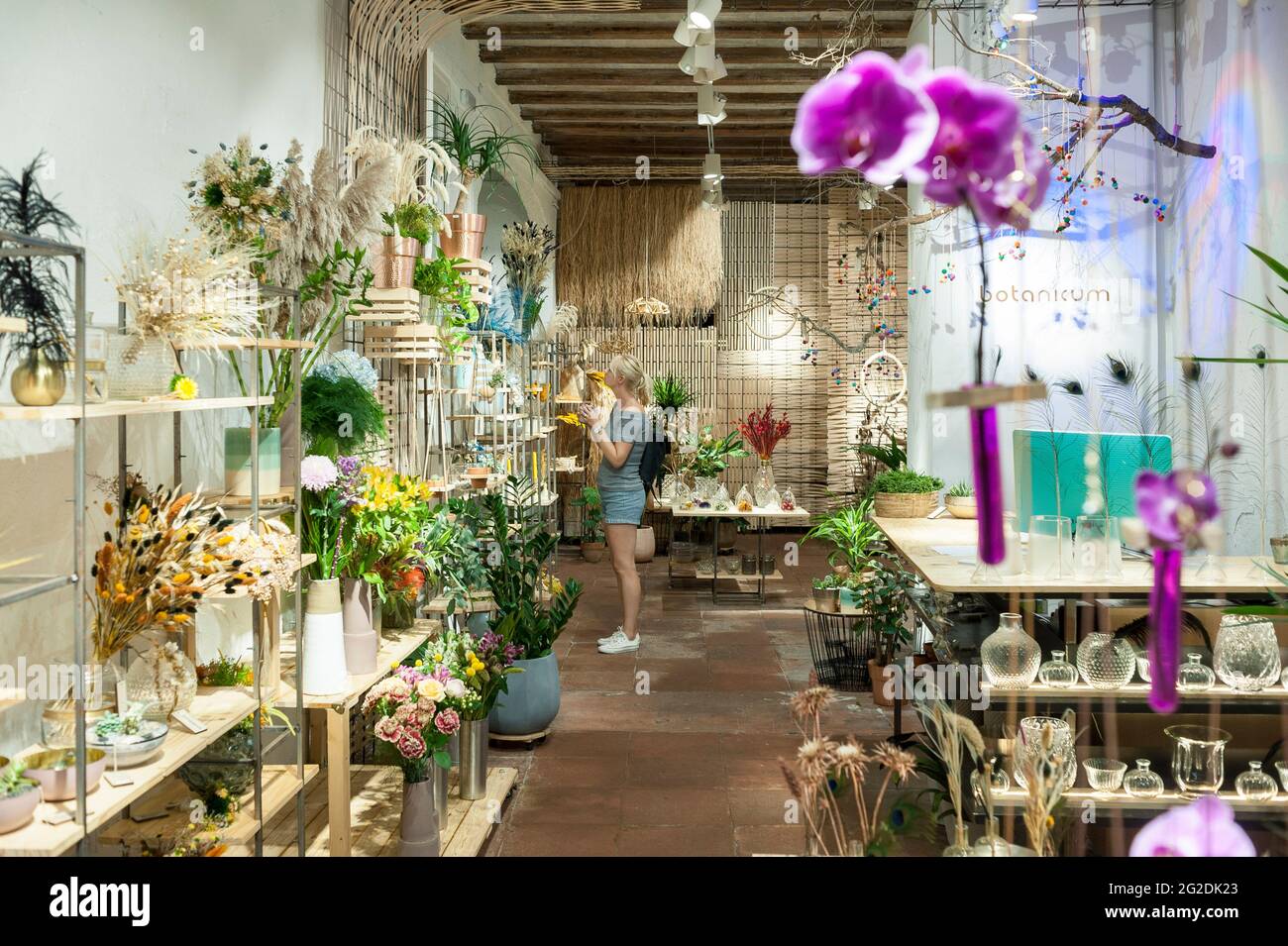 Une femme se tient dans un magasin de fleurs / plantes à Barcelone pendant les vacances / vacances. Banque D'Images