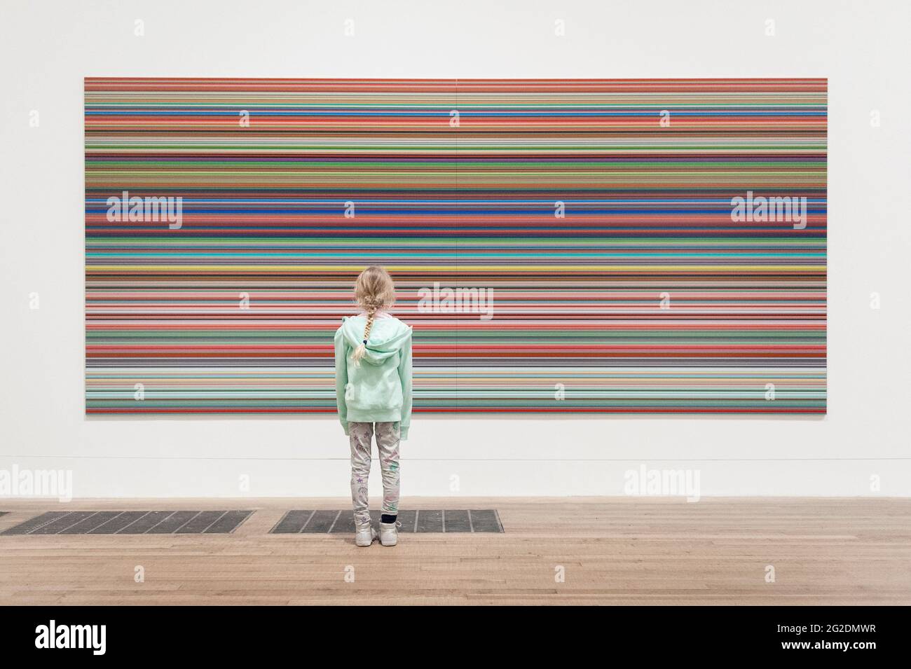 Une fille se tient devant un grand tableau Bridget Riley dans la Tate Modern Art Gallery. Banque D'Images