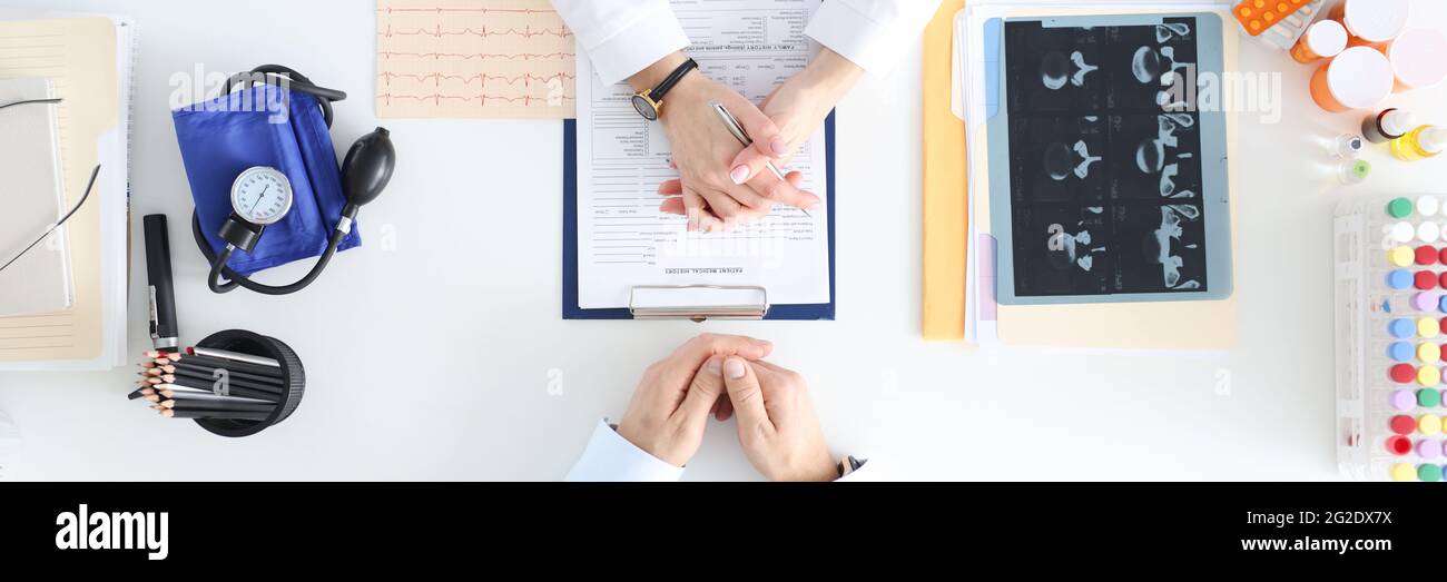 Médecin communiquant avec le patient à la table dans la vue de dessus de l'établissement Banque D'Images