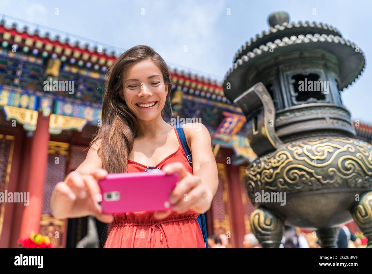 Touriste en utilisant un téléphone mobile prendre des photos de l'ancienne sculpture de bronze de temple à Beijing, chine. Voyage touristique Asie. Personnes pendant les vacances Banque D'Images
