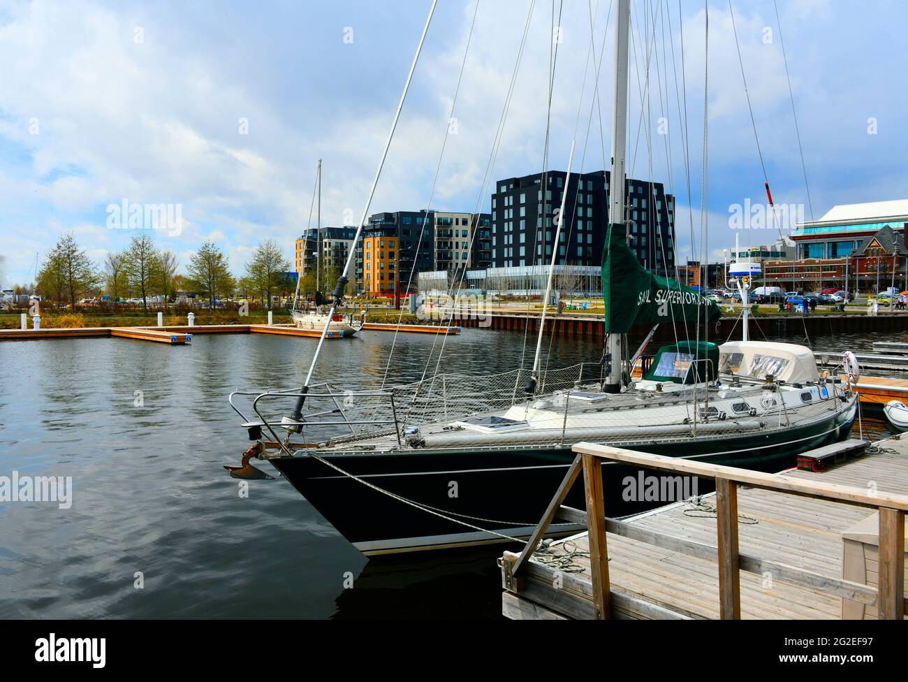 Un voilier est amarré à Marina Park, dans le lac supérieur, avec des appartements, un hôtel et des bureaux gouvernementaux à proximité du lac, par une journée semi-nuageux. Banque D'Images