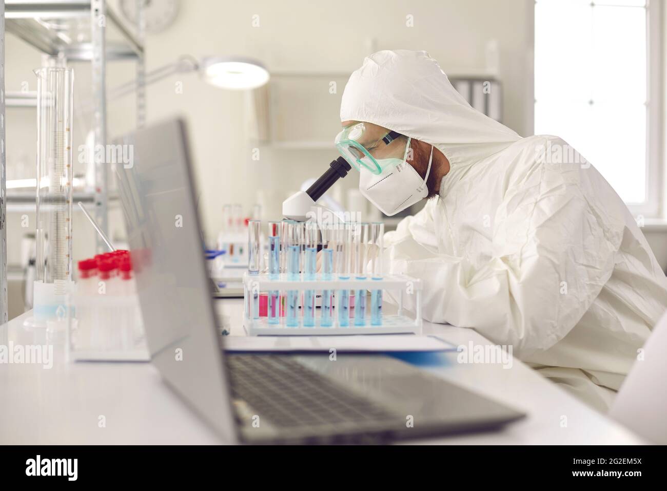 Scientifique travaillant en laboratoire, utilisant un microscope, faisant de la recherche et mettant au point un nouveau vaccin Banque D'Images