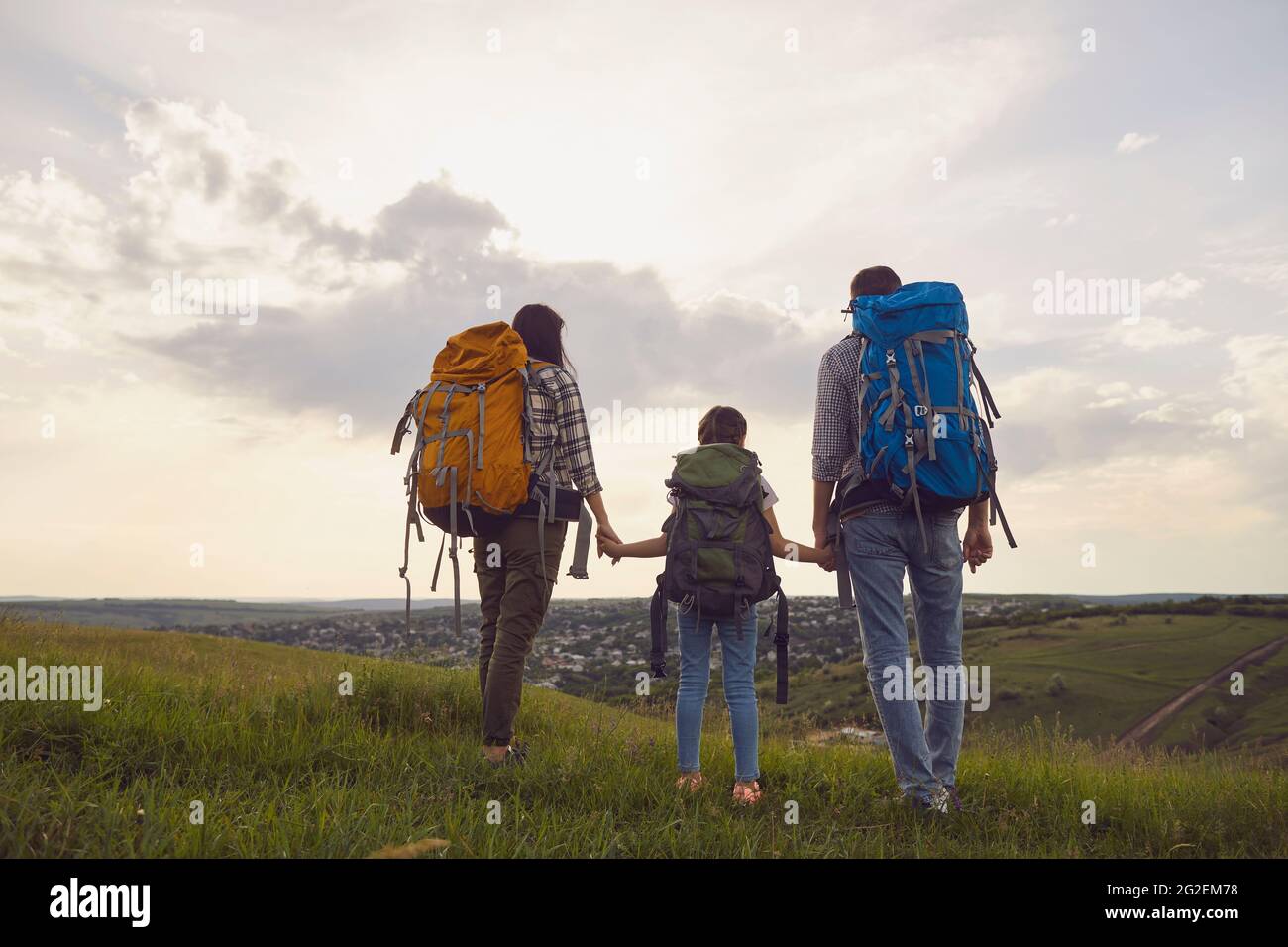 Famille avec sacs à dos. Touristes debout dans la nature randonnée le soir. Vue arrière. Banque D'Images