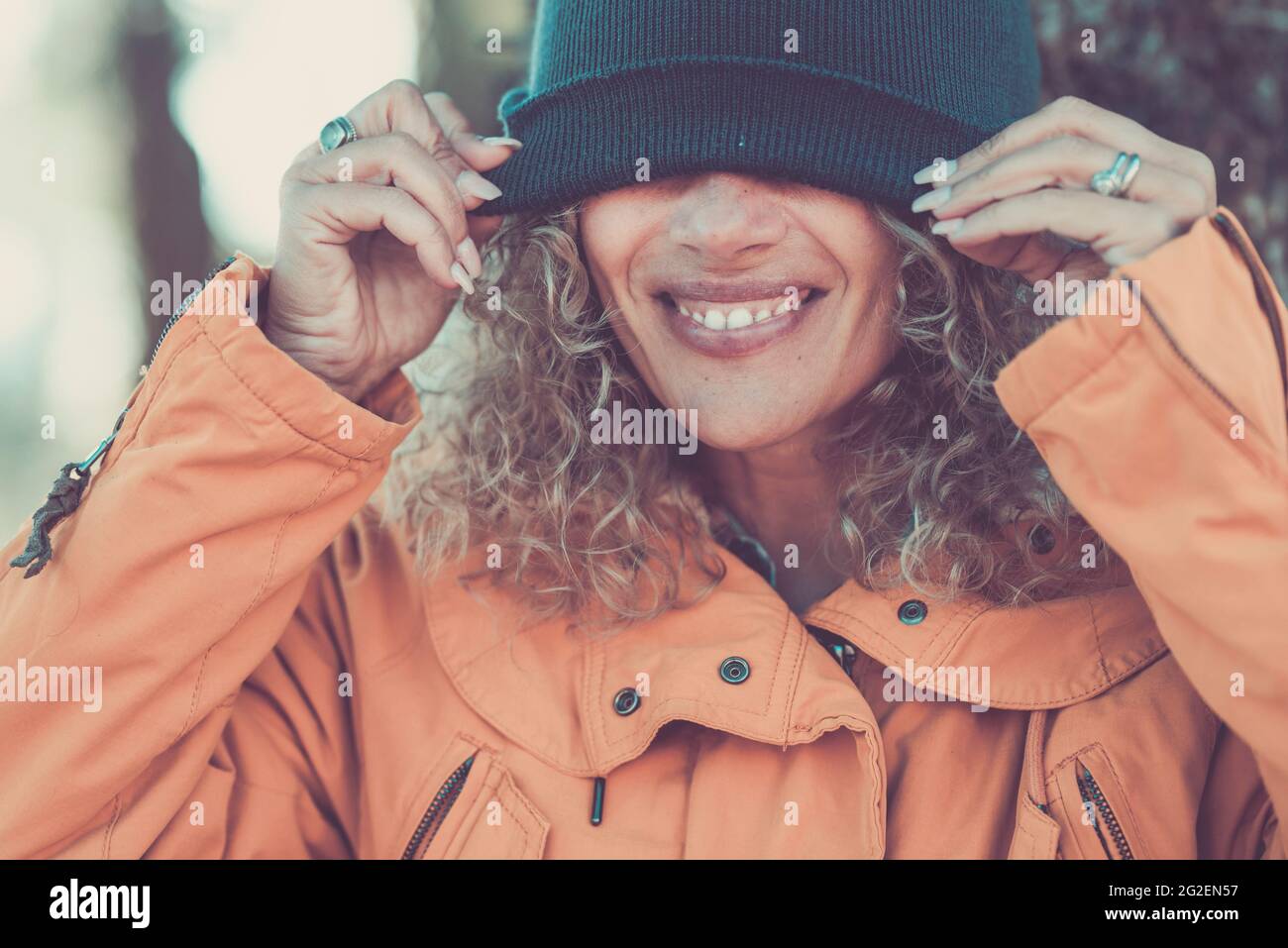 Joyeuse belle femme portrait couvrant ses yeux avec coupe d'hiver - les gens heureux profiter des activités de loisirs en plein air - joli sourire et le concept des dents - m Banque D'Images