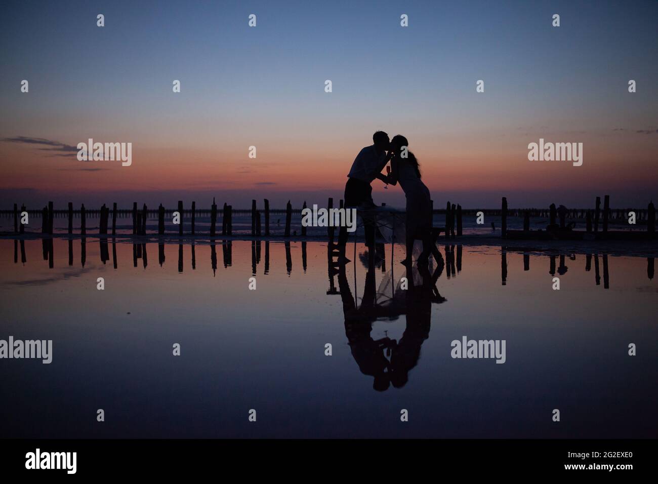 couple de mariage aimant au coucher du soleil sur le lac rose Banque D'Images
