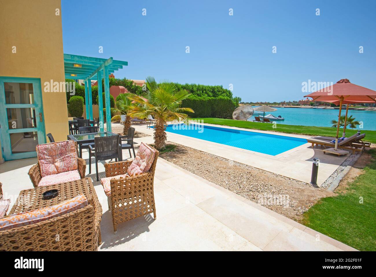Villa de luxe show home dans un complexe tropical de vacances d'été avec piscine et chaises longues dans le jardin Banque D'Images