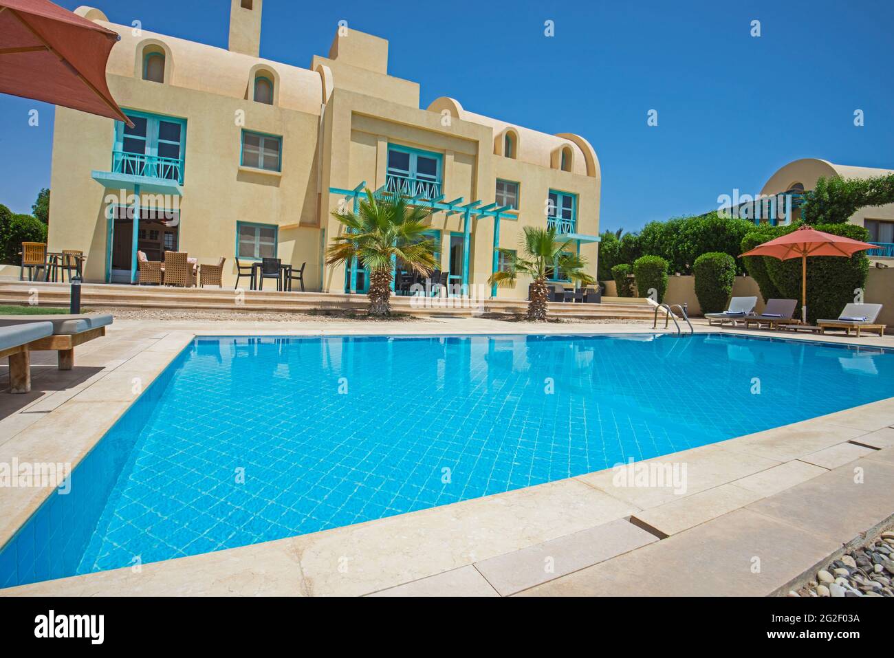 Villa de luxe show home dans un complexe tropical de vacances d'été avec piscine et chaises longues dans le jardin Banque D'Images
