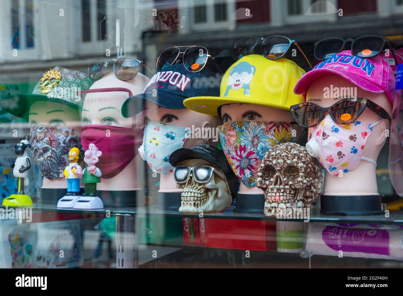 Masques pour le visage à vendre dans la vitrine du magasin à Bournemouth,  Dorset Royaume-Uni en juin - têtes de mannequin portant des casquettes de  baseball et des masques pour le visage
