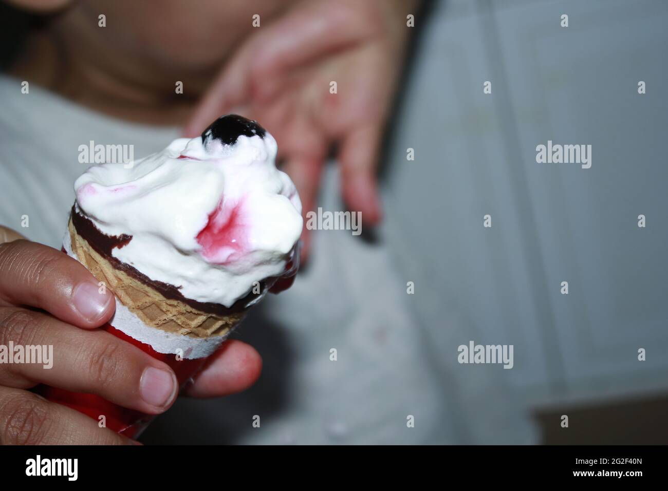 Un enfant qui mange de la glace de cône photographie en gros plan. Banque D'Images