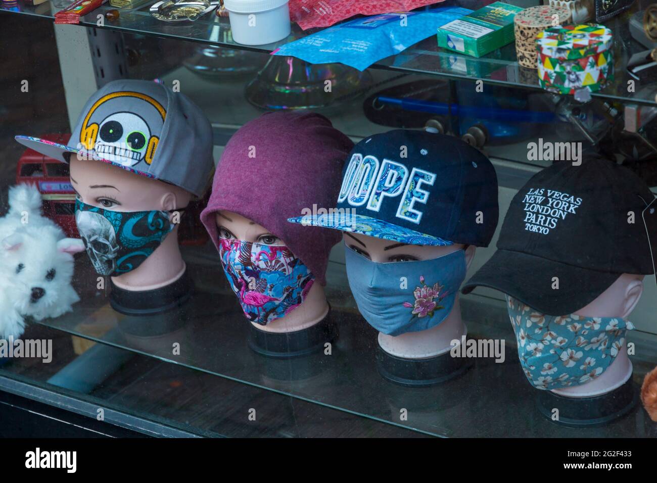 Masques pour le visage à vendre dans la vitrine du magasin à Bournemouth, Dorset Royaume-Uni en juin - têtes de mannequin portant des casquettes de baseball et des masques pour le visage masque pour le visage Banque D'Images
