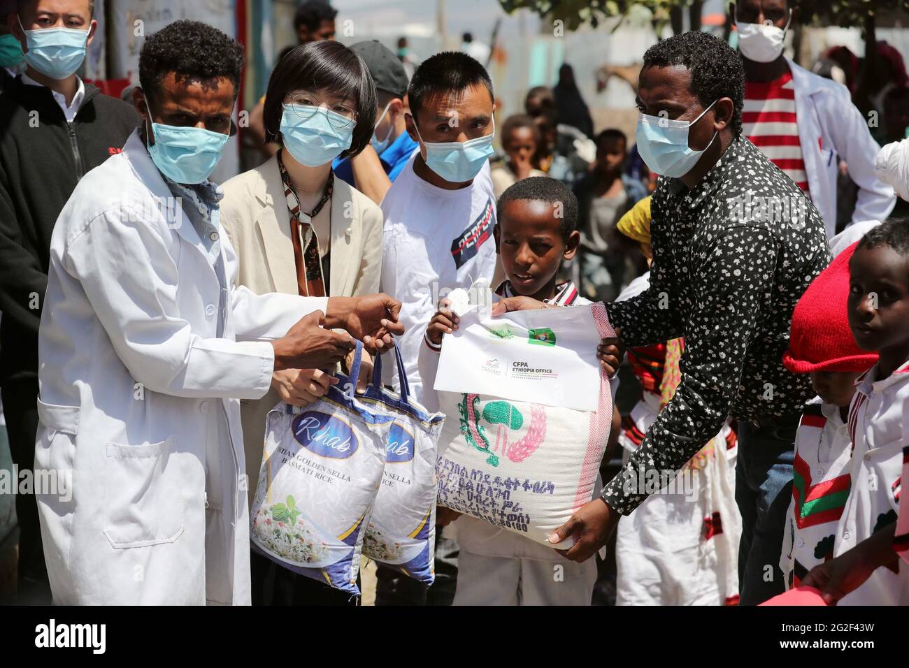 Dukem, École primaire d'Obaay dans la ville de Dukem, dans l'État régional d'Oromia en Éthiopie. 9 juin 2021. Huang Xiaocen (2e L, front), directeur adjoint de la Fondation chinoise pour l'atténuation de la pauvreté (CFPA) Éthiopie, distribue de la nourriture aux étudiants locaux de l'école primaire d'Obaay, dans la ville de Dukem, dans l'État régional d'Oromia en Éthiopie, le 9 juin 2021. La CFPA a distribué mercredi des colis alimentaires à plus de 400 élèves de l'école primaire d'Obaay, dans la ville de Dukem, dans l'État régional d'Oromia en Éthiopie. Crédit : Wang Ping/Xinhua/Alay Live News Banque D'Images