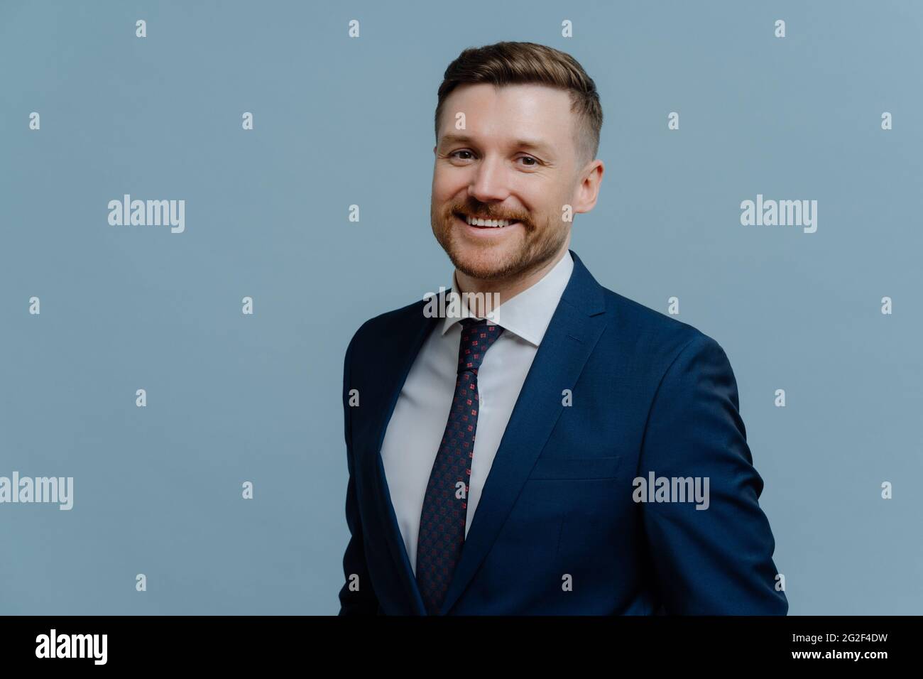 Portrait d'un homme d'affaires en costume souriant à l'appareil photo Banque D'Images