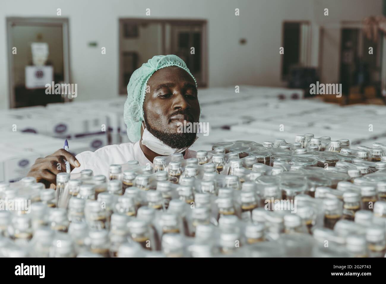 Travailleur africain noir travaillant dans l'industrie des produits d'usine vérifiant le stock de stock dans l'entrepôt. Banque D'Images