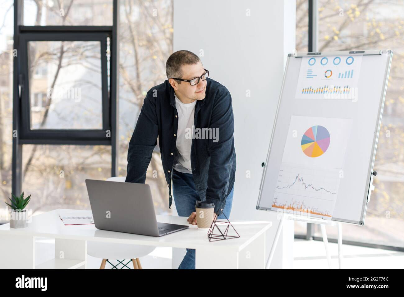Un homme physique fort habille dans des vetements decontractes travaille dans le bureau. L homme travaille dans un lieu de travail eloigne Photo Stock Alamy