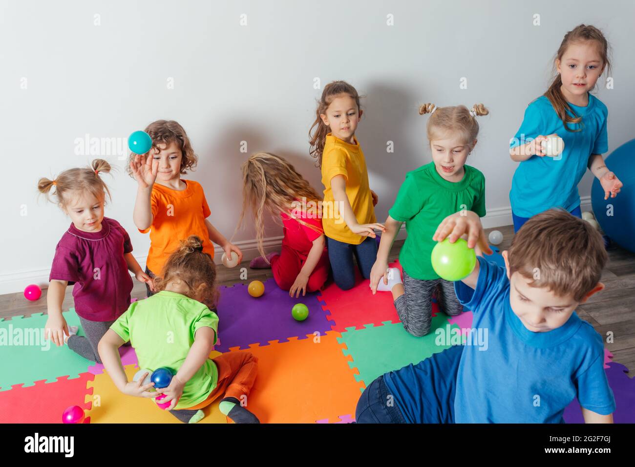 Des jeunes énergiques jettent de nombreuses balles colorées Banque D'Images