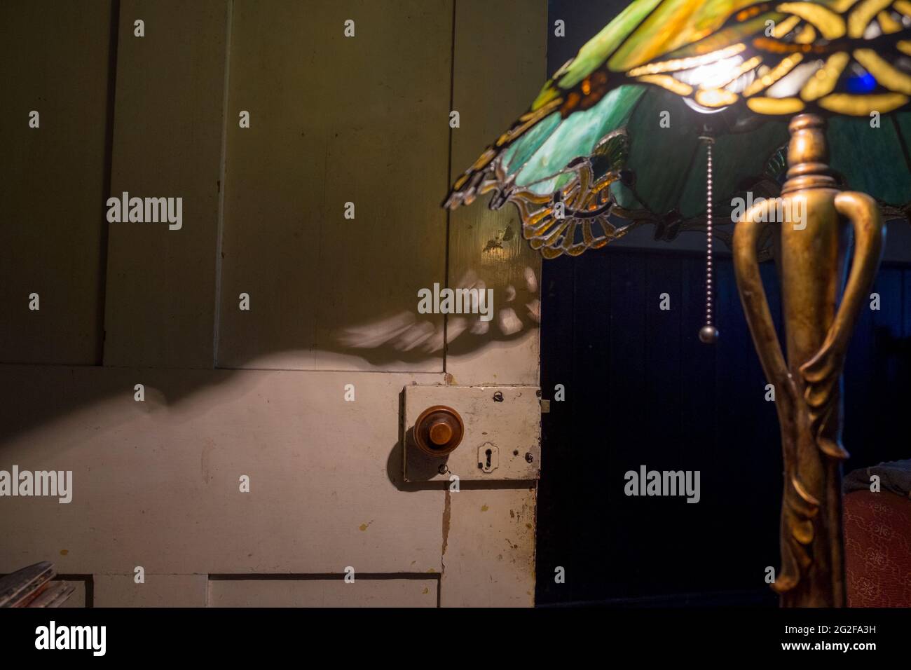 Une lampe Art nouveau avec abat-jour en verre teinté de style Tiffany créant de belles ombres. --- UN week-end à Brooklyn House, Martham Banque D'Images