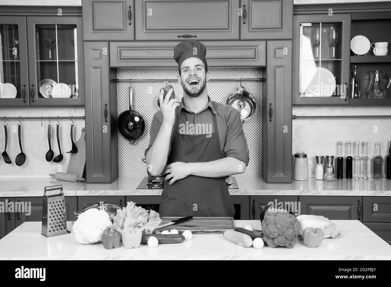 Jeune homme préparant des aliments délicieux et sains avec des légumes Banque D'Images