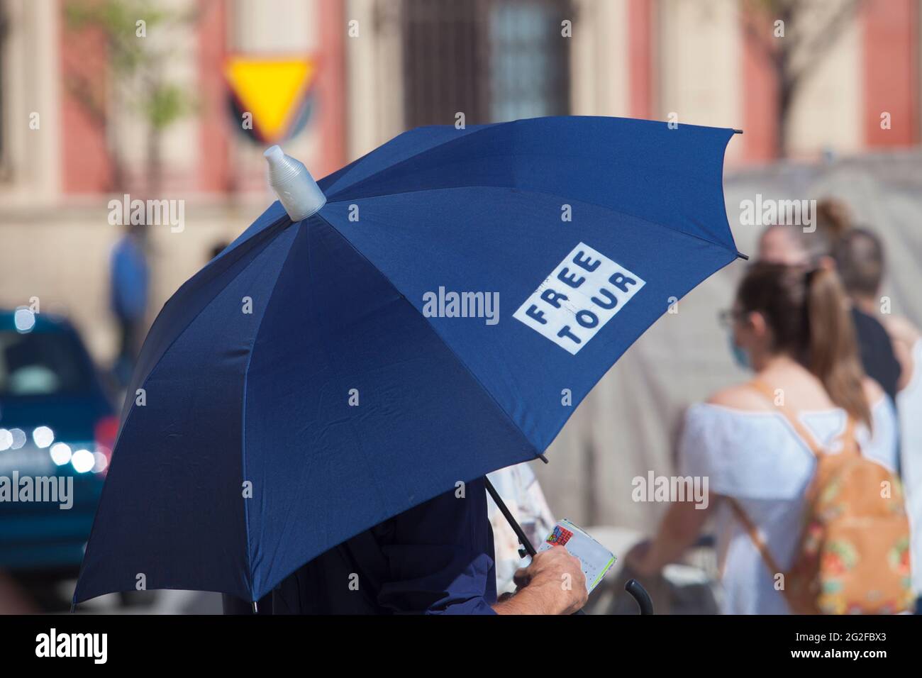 Guide gratuit pour homme avec parapluie bleu. Quartier de Santa Cruz, quartier historique de Séville, Espagne Banque D'Images