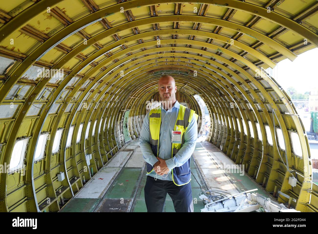 11 juin 2021, Hambourg: Jens-Peter Franz, chef de projet de la maison de vente aux enchères industrielle Dechow, se trouve dans le fuselage partiellement vidé d'un Boeing 707-430. L'un des plus anciens avions à réaction de Lufthansa a été démantelé à Hambourg depuis vendredi. Une fois l'intérieur enlevé, une entreprise spéciale a commencé à scier le Boeing 707-430 avec l'enregistrement D-ABOD. La maison de vente aux enchères industrielle Dechow veut vendre aux enchères autant de parties individuelles de l'avion traditionnel que possible en septembre, avec les parties d'un avion du même type qui a été démonté à Berlin-Tegel Banque D'Images