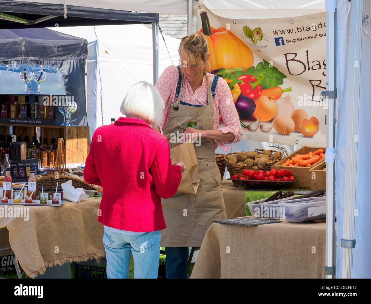 Femme achetant des légumes au marché des fermiers et de l'artisanat de Bude, Cornwall, Royaume-Uni Banque D'Images